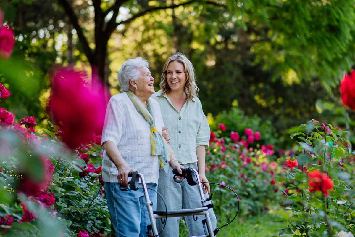 Daughter walking outside with mother in garden